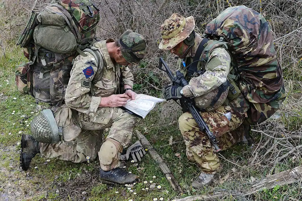 British and Italian soldiers consulting a map during a joint exercise